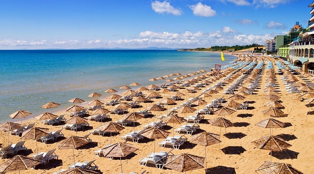 sun beds and umbrellas lined up on the golden sand beach in bulgaria on a sunny day